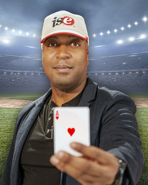 Fred Livingston holding a ace card in front of a stadium.
