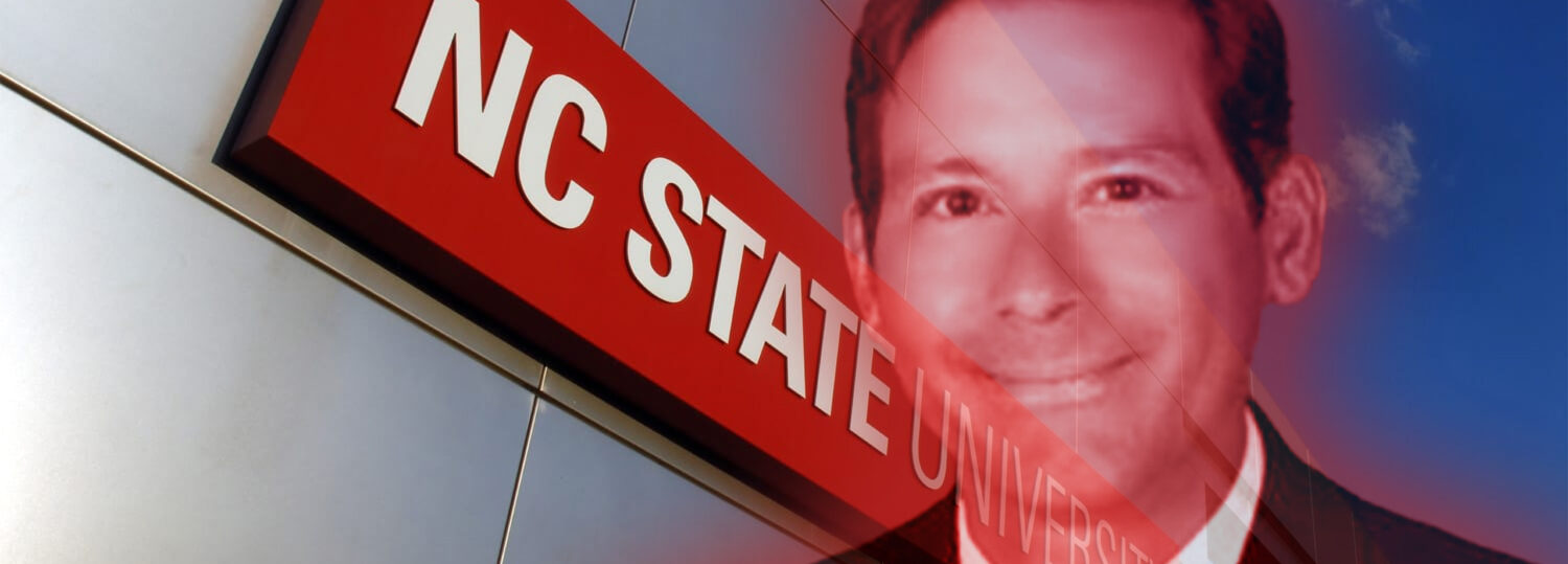 A headshot of professor Christopher Rock in front of the NC State Gateway
